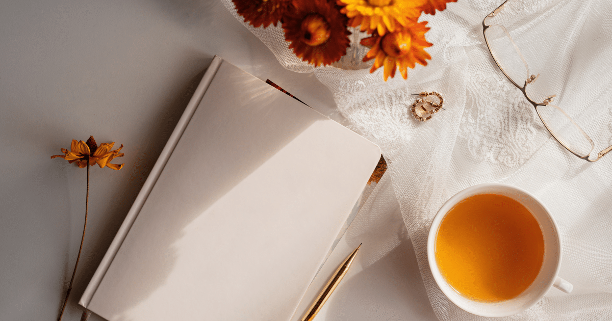 Gratitude journal on a table next to tea and fall flowers to showcase blog on 5 Reasons You Might Pass on Gratitude this Thanksgiving.