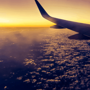 View from airplane window with aircraft wing visible in flight
