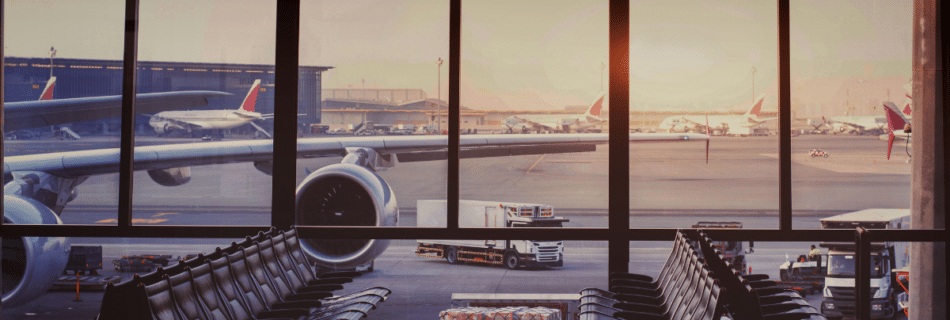 View from an airport window of a commercial airplane parked at the gate before departure.